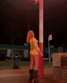 a woman squatting next to a red and white pole