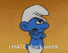 a smurf with his arms crossed and the words i hate shark week