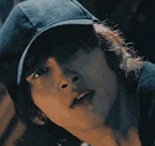 a close up of a person wearing a hat and a hoodie .
