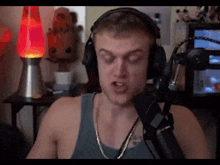 a man wearing headphones and a microphone is making a funny face .