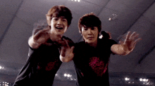 two young men are standing next to each other with one wearing a t-shirt that says tour