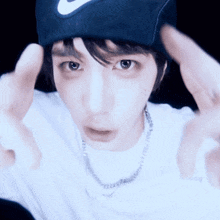 a man wearing a nike hat and a necklace