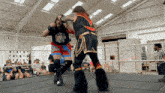 two wrestlers are fighting in a ring and one of them has a shirt that says up