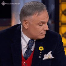 a man in a suit with a yellow flower pin in his pocket
