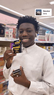 a man in a white shirt is holding up a magnum box