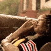a woman is smoking a cigarette while laying on a couch .