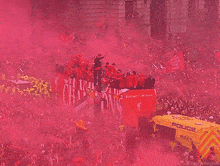 a crowd of people are gathered in front of a building with red smoke coming out of it and a sign that says champions