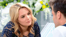 a woman in a blue dress is looking at a man