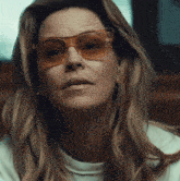a close up of a woman wearing sunglasses and earrings
