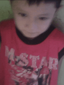 a young boy is wearing a red shirt that says mstar