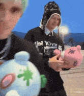 a person wearing a sweater that says ' us ? 10 ' on it holds a stuffed animal