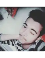 a young man with his eyes closed and a striped shirt on