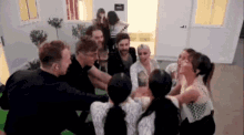 a group of people are standing in a circle with their hands on each other .