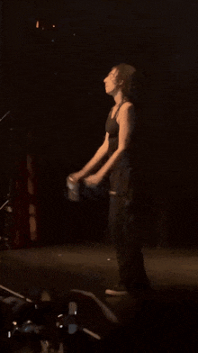 a man is dancing on a stage in front of a crowd with a cell phone in the foreground