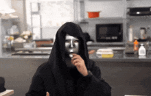 a person wearing a hooded sweatshirt and a mask on their face