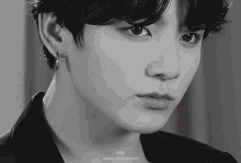 a black and white photo of a young man 's face with a caption that says ' jungkook 1997 '