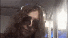 a woman with long hair is wearing headphones and sunglasses ..