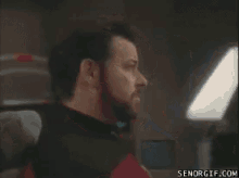 a man with a beard is talking on a cell phone with senorgif.com in the corner
