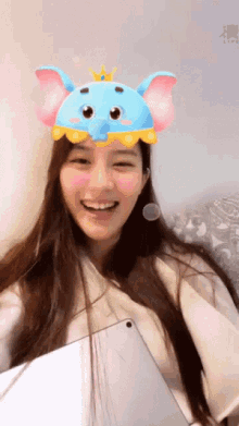 a woman wearing a blue elephant hat with a crown on it