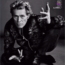 a black and white photo of a man kneeling down with his hands outstretched