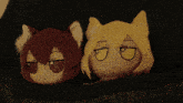 two stuffed animals with yellow eyes are laying next to each other on a couch