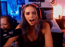 a woman wearing headphones is sitting in front of a shure microphone in a bedroom