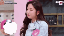 a woman with long hair is wearing a name tag that says ' n ' on it .