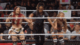 a woman holding a sign that says kota is a in a wrestling ring