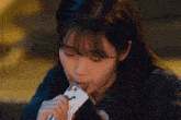 a woman is eating a piece of paper with a drawing of a rabbit on it