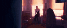a woman in a black dress is standing in a room next to a window