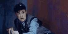 a young man in a plaid shirt is looking at something with his mouth open and a surprised look on his face