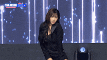 a woman is dancing on a stage in front of a screen that says show international