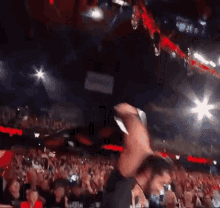 a crowd of people watching a wrestling match in a stadium with a sign that says ' wrestling ' on it