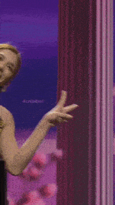 a woman in a black and gold top is giving the peace sign
