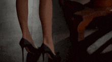 a woman 's legs are shown standing next to a wooden table