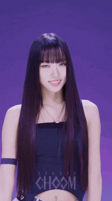 a woman with long purple hair is wearing a black top with choom written on it