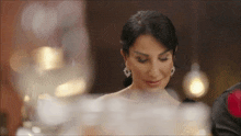 a woman in a white dress and earrings is looking down