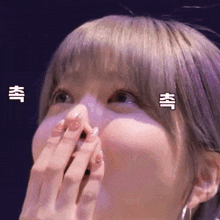 a woman is covering her mouth with her hand .