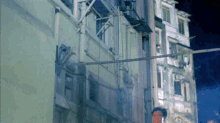 a man standing in front of a building with a fire escape