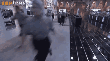 a blurred image of people running in a kitchen with the word top chef on the wall behind them