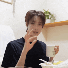 a young man is holding a white mug that says temp on it