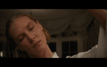 a man in a white shirt is sitting on a bed