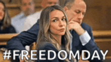 a man and a woman are sitting in a courtroom with the words `` freedom day '' written on the bottom .