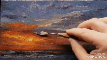 a person is painting a sunset with a spatula and the words made in animotica are visible