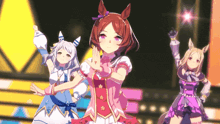 a group of anime girls are dancing on a stage with one girl wearing a pink dress with flowers on it