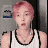 a young man with pink hair is wearing headphones