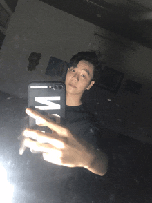 a young man taking a selfie with a phone case that says w on it