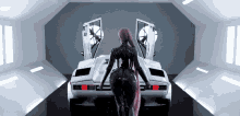 a woman stands in front of a white sports car