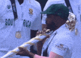 a man in a green hat is holding a trophy that says south africa