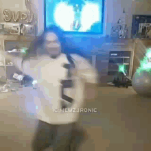 a person is dancing in a living room in front of a tv .